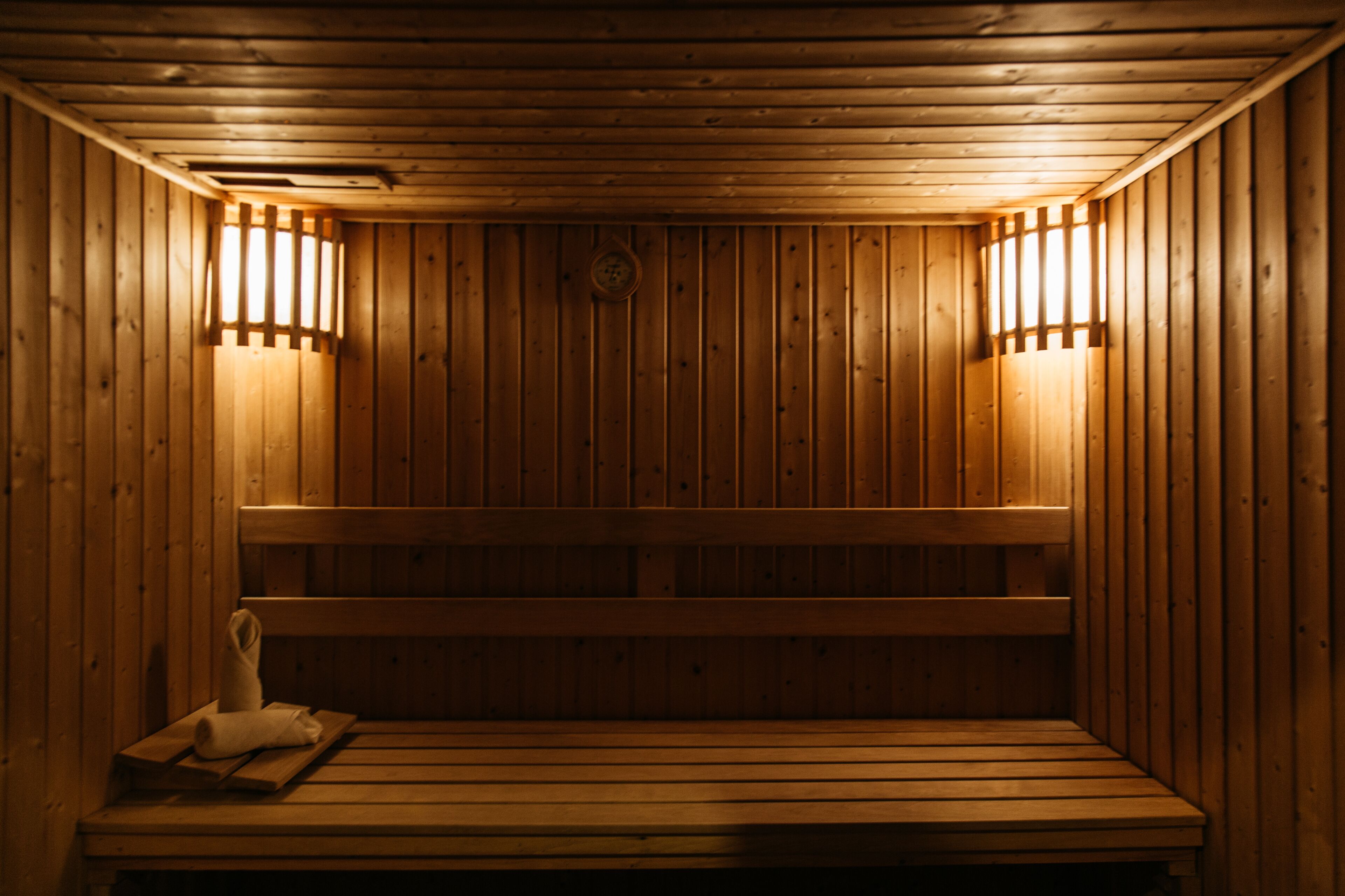 Una sauna con bancos de madera e iluminación en la pared.