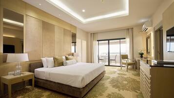 Habitación de hotel con una cama grande, un escritorio, una silla y vistas al exterior.