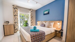 Une chambre à coucher avec un lit, une table de chevet et une vue sur la verdure.