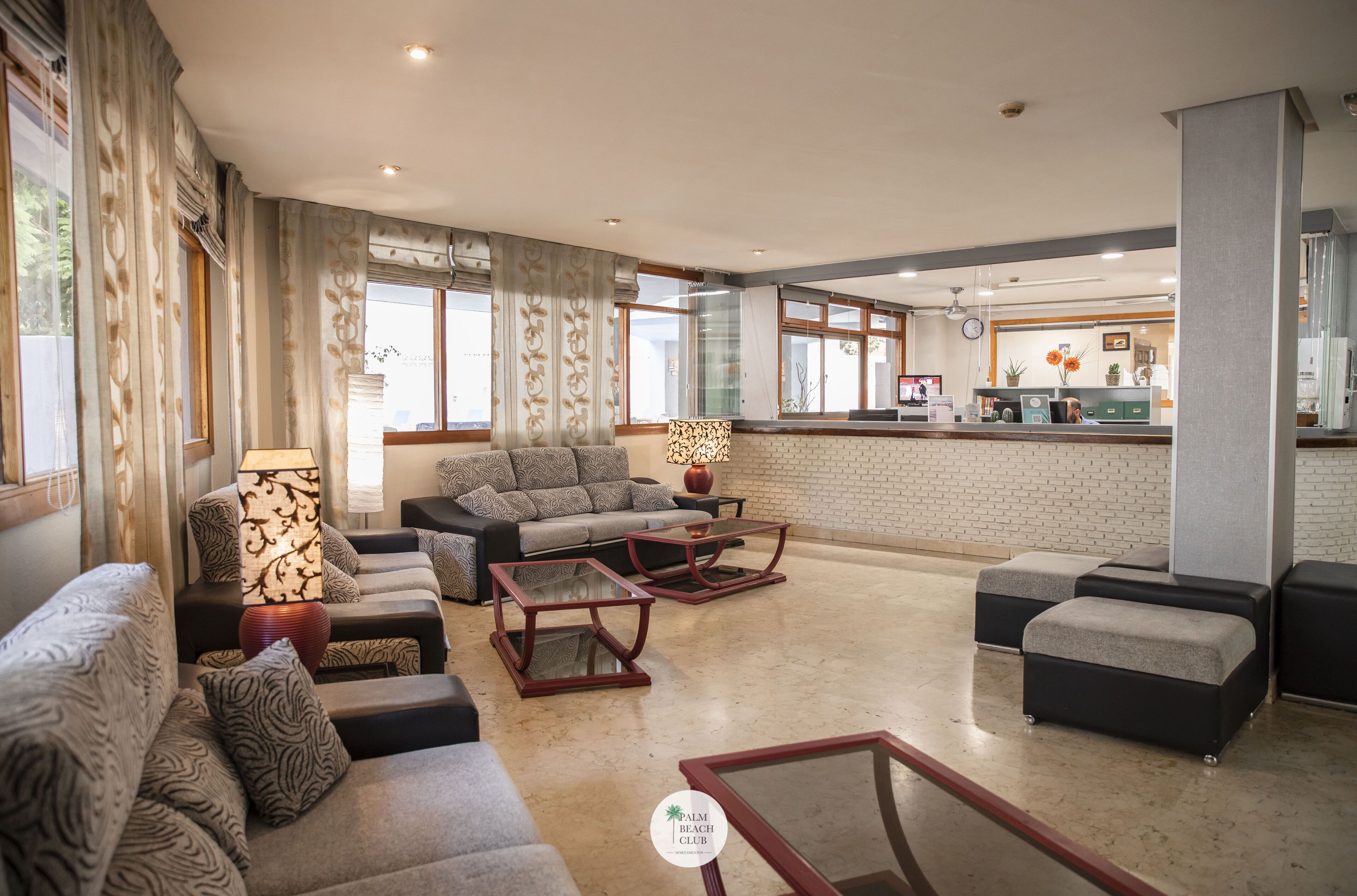 A spacious living area with sofas, a coffee table, and a reception desk.