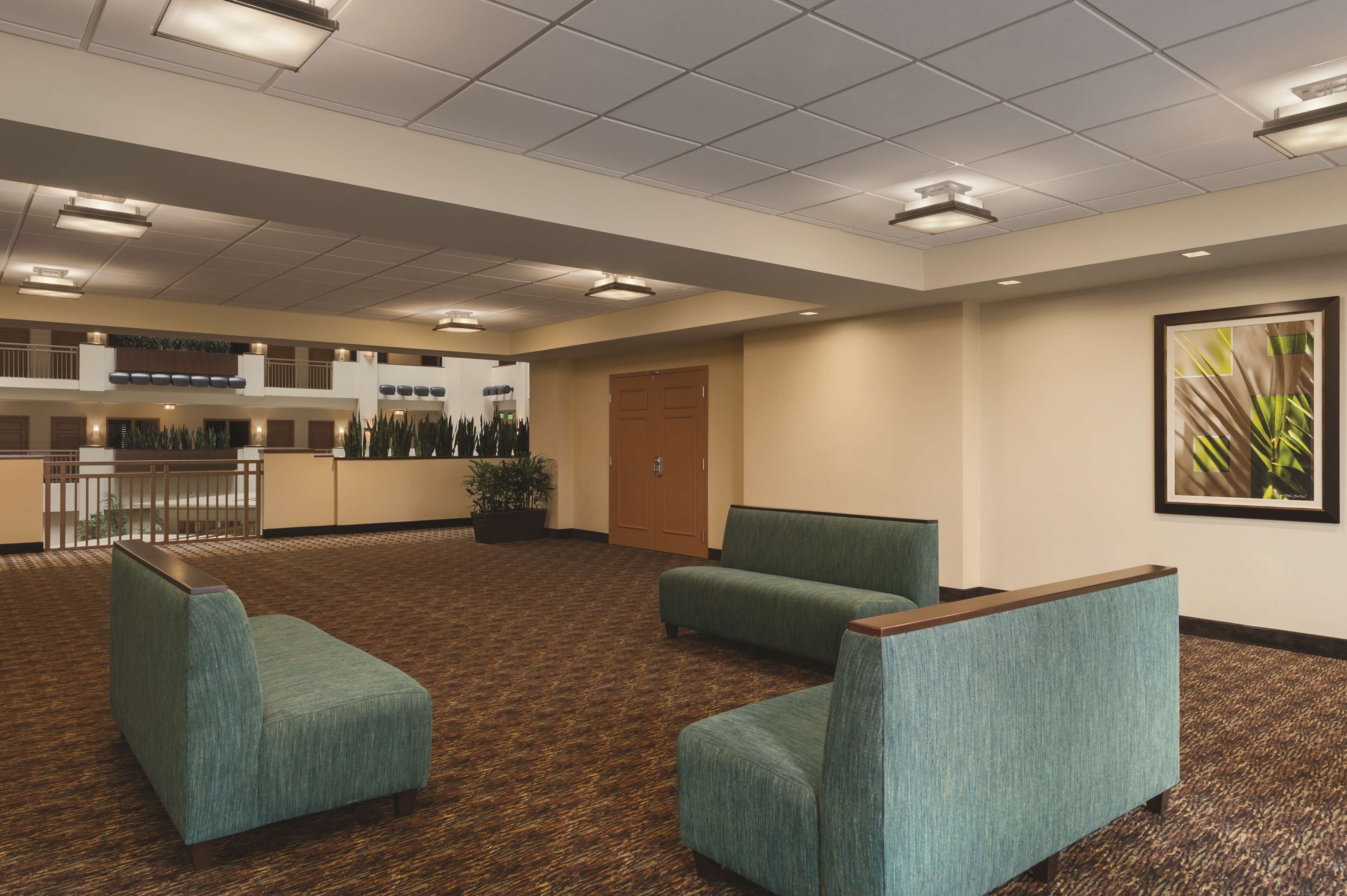 A hotel lobby with a reception desk, seating area, and a door.