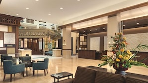 A spacious lobby with a reception desk, seating area, and a decorative flower arrangement. - Embassy Suites by Hilton Orlando Lake Buena Vista South (Kissimmee)