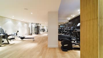 Ein modernes Fitnessstudio mit Cardiogeräten, Krafttrainingsgeräten und einer Spiegelwand.