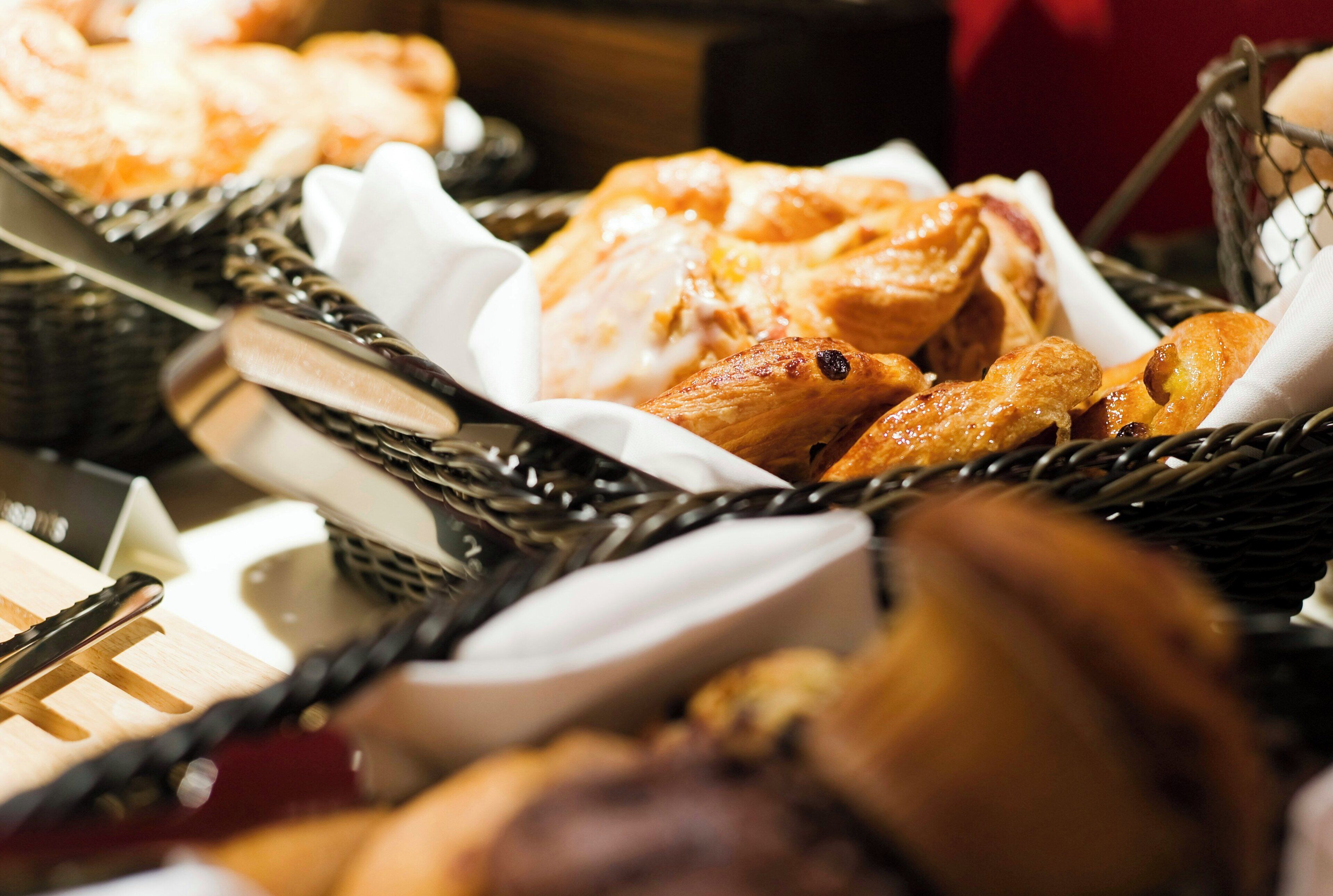 A selection of baked goods in baskets, including bread and pastries.