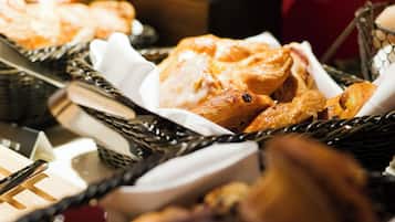 A selection of baked goods in baskets, including bread and pastries.