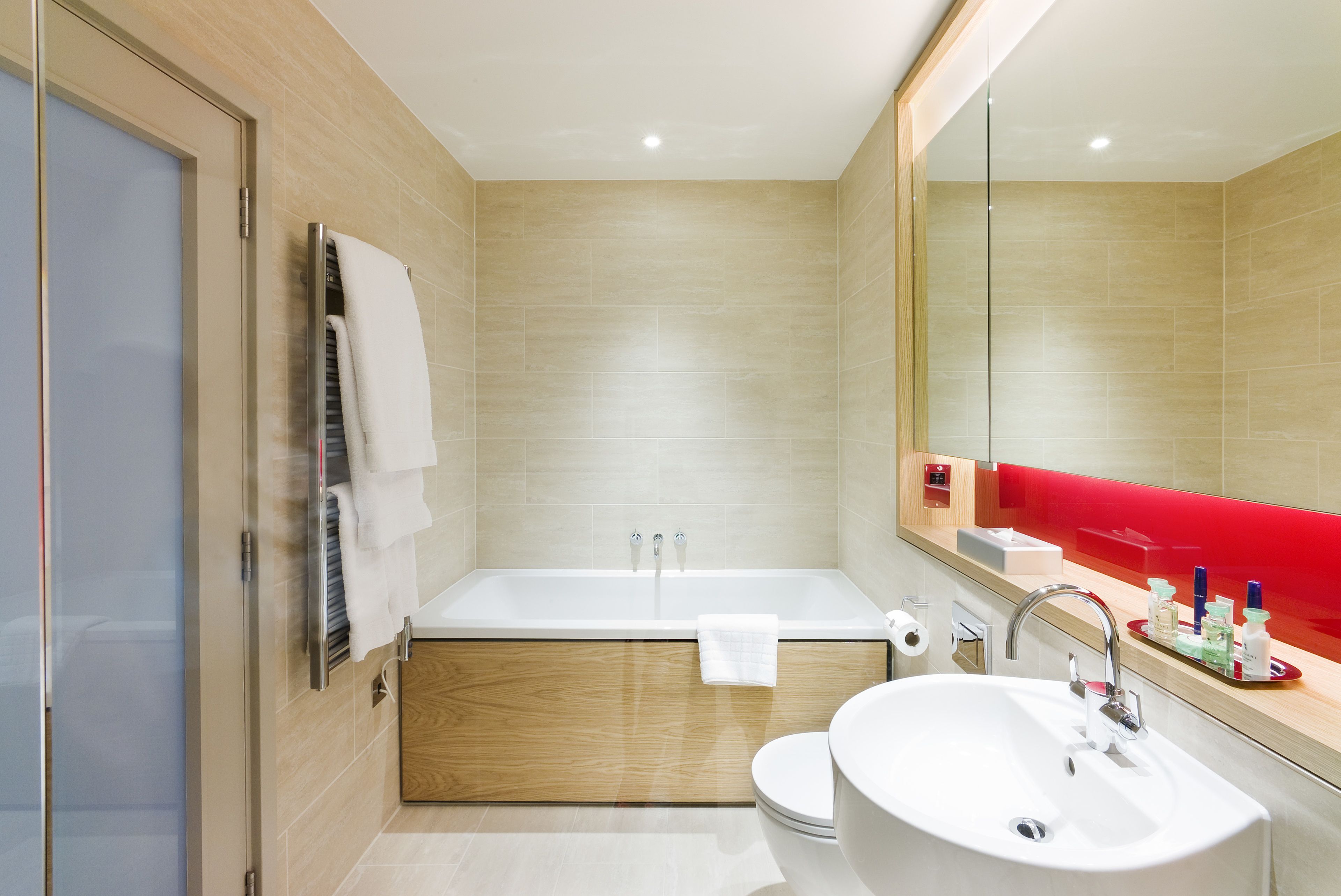 A modern bathroom with a bathtub, toilet, and sink.