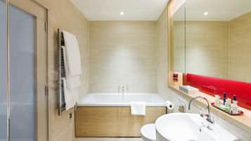 A modern bathroom with a bathtub, toilet, and sink.