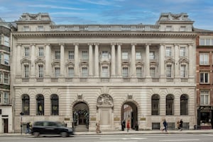 A large, classical building with a symmetrical facade, multiple windows, and a central entrance with a decorative arch.