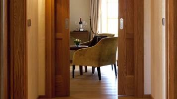A hallway with wooden doors and a dining area with a table and chairs.