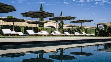 Una piscina cubierta, una piscina al aire libre de temporada, sombrillas