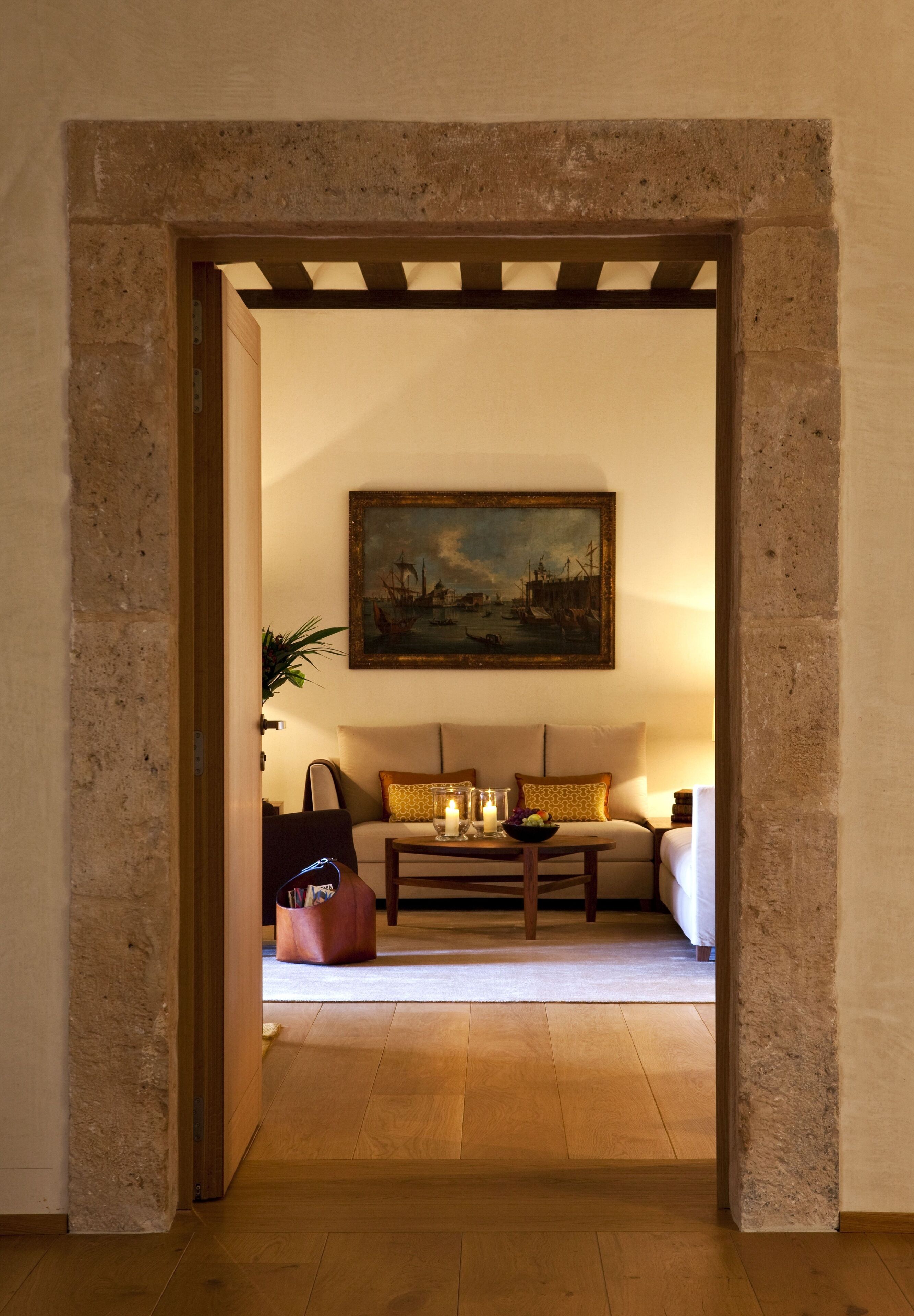 Una sala de estar acogedora con suelo de madera, un conjunto de sofás, una mesa de centro y un cuadro en la pared.