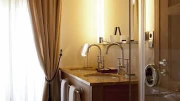A bathroom with a wooden vanity, a glass shower enclosure, and a large mirror.