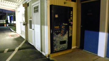 A building entrance with a closed door, a small window, and a fire extinguisher mounted on the wall.