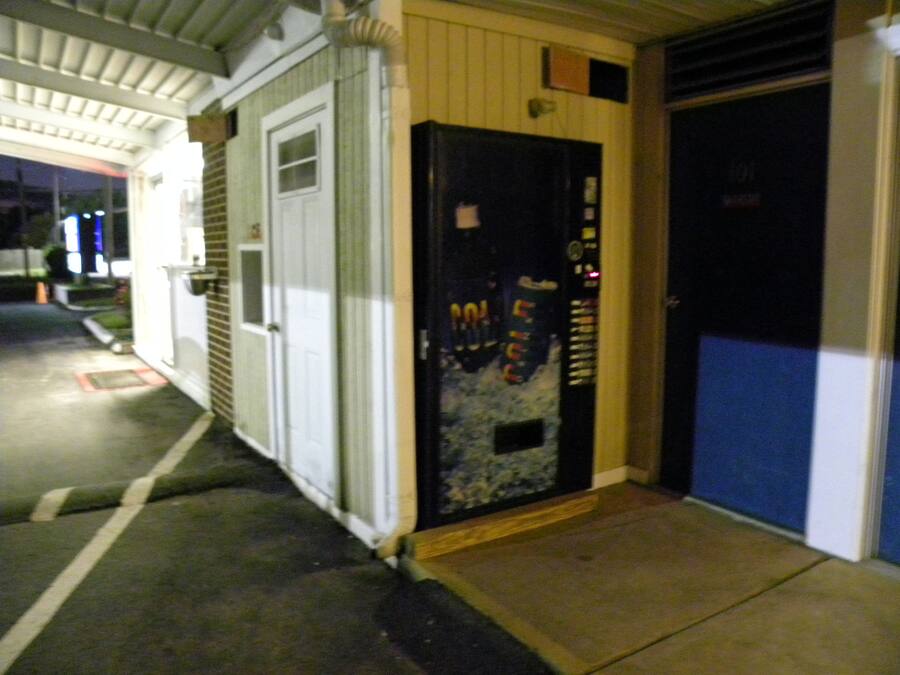 A building entrance with a closed door, a small window, and a fire extinguisher mounted on the wall.