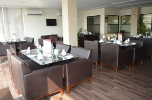A modern hotel dining area with leather booths and tables set for dining. - Hotel One Down Town (Lahore)