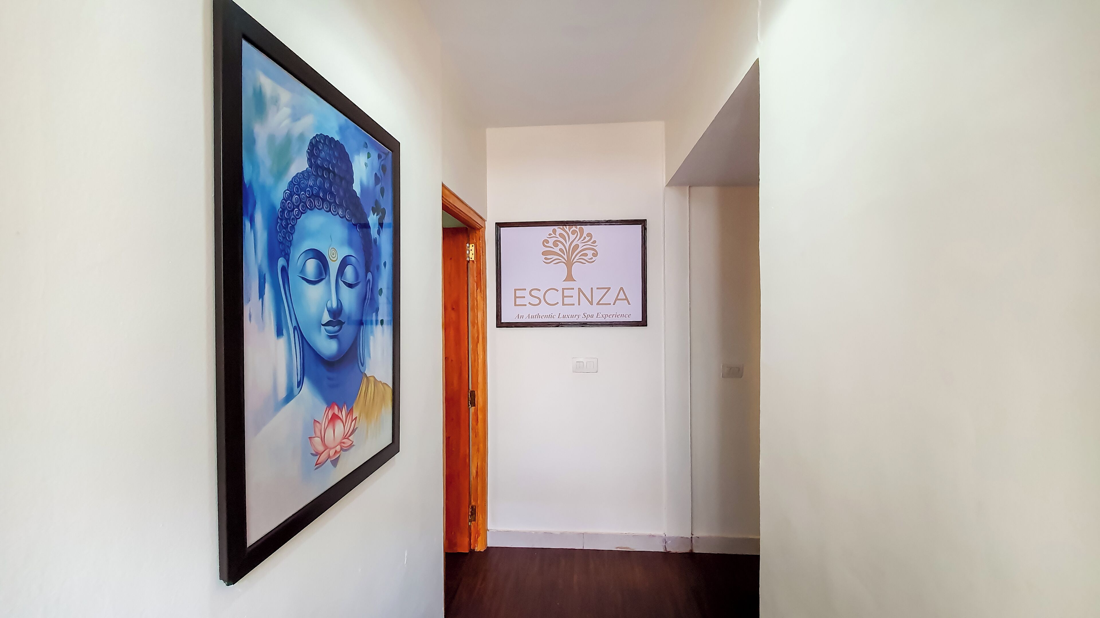 A hallway with a framed Buddha painting and a spa sign.