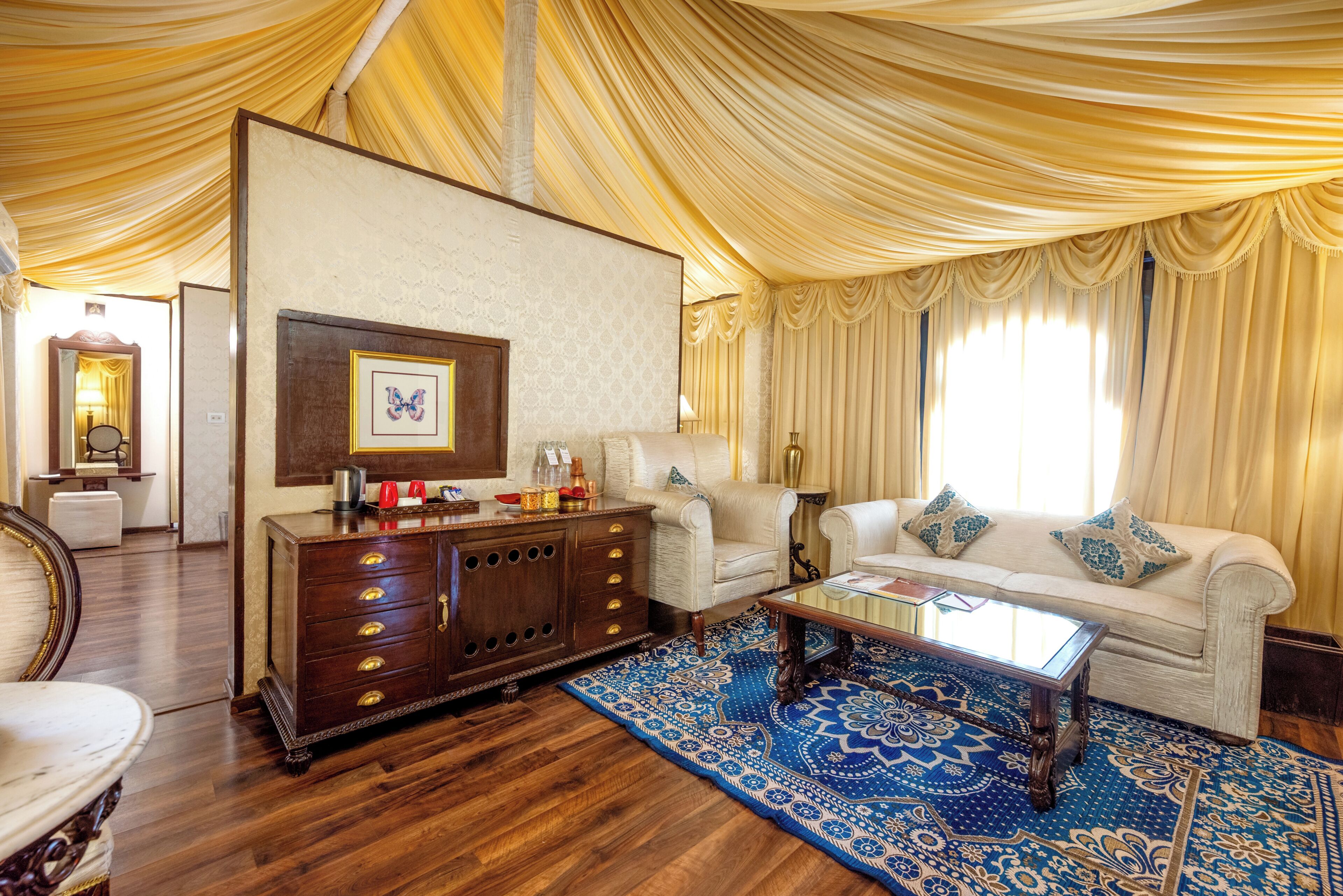 A room with a wooden cabinet, a sofa, a coffee table, and a patterned rug.