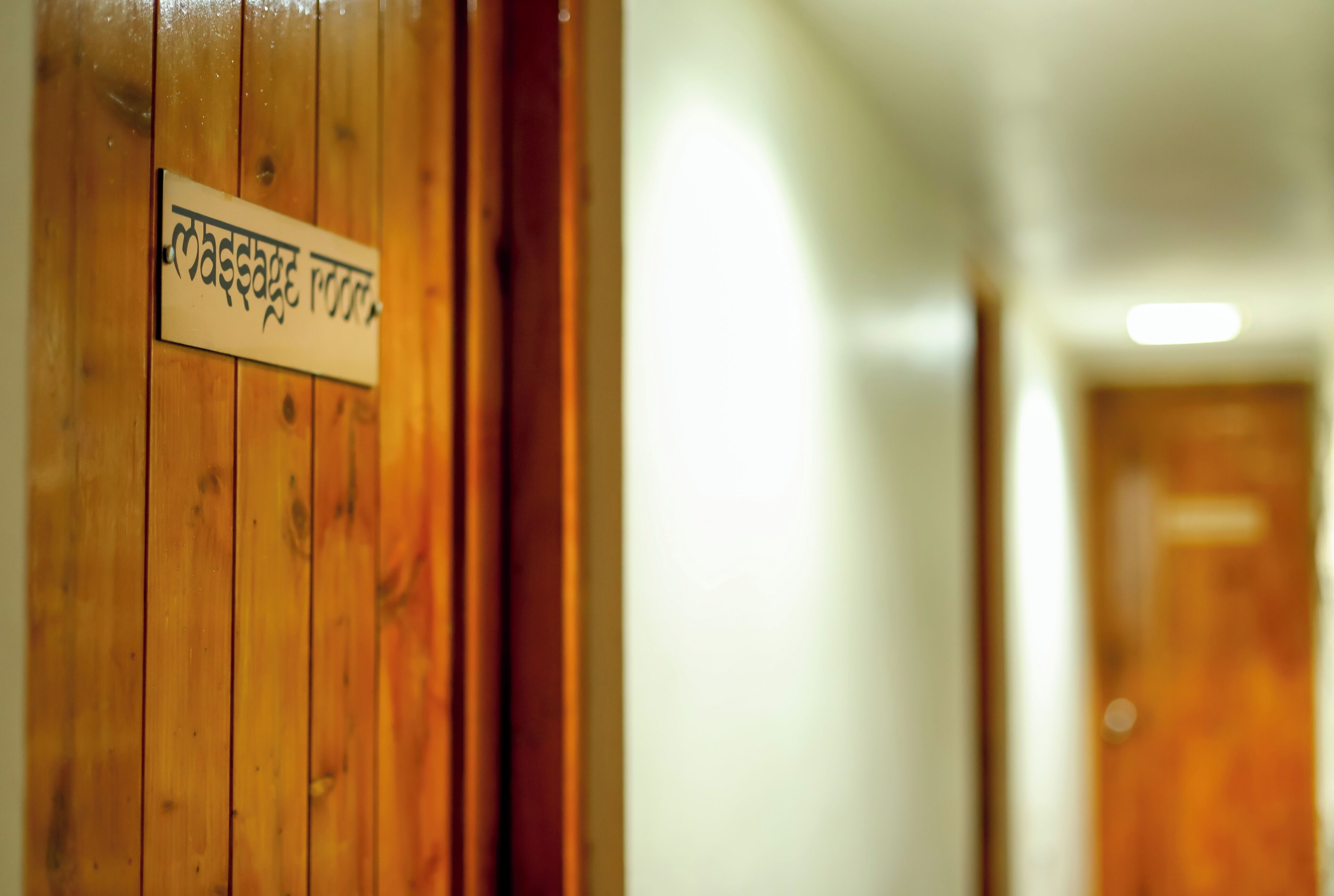 Puerta de madera con un letrero que indica una sala de masajes.