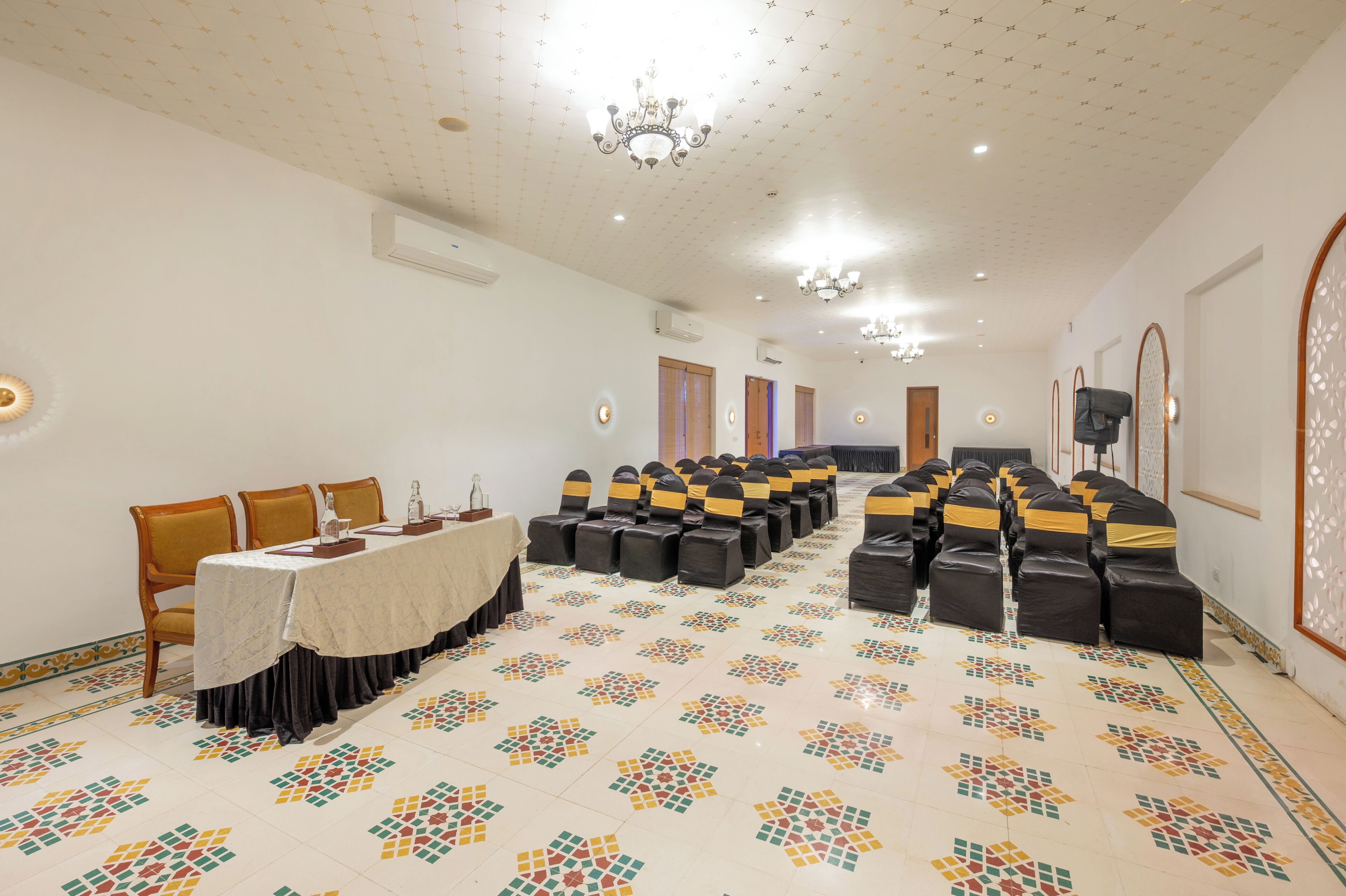 A conference room with a long table, chairs, and a patterned floor.