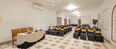 A conference room with a long table, chairs, and a patterned floor.