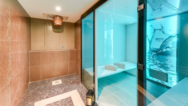 A modern bathroom with a glass partition, a wooden bathtub, and a tiled floor. - ibis Styles Nantes Saint Herblain (Saint-Herblain)