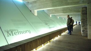 Un pasillo con una pared larga que muestra texto y piso de madera.
