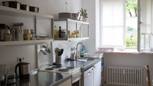 Una cocina moderna con electrodomésticos de acero inoxidable, armarios blancos y un ventanal con vistas al verdor.