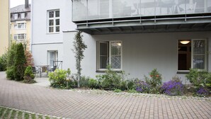Un edificio con un sendero adoquinado y un jardín con diversas plantas.