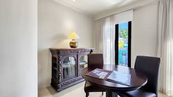 A room with a round table, two chairs, a lamp, and a decorative cabinet.
