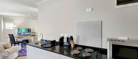 A modern kitchen with a central island, a built-in microwave, and a stove.