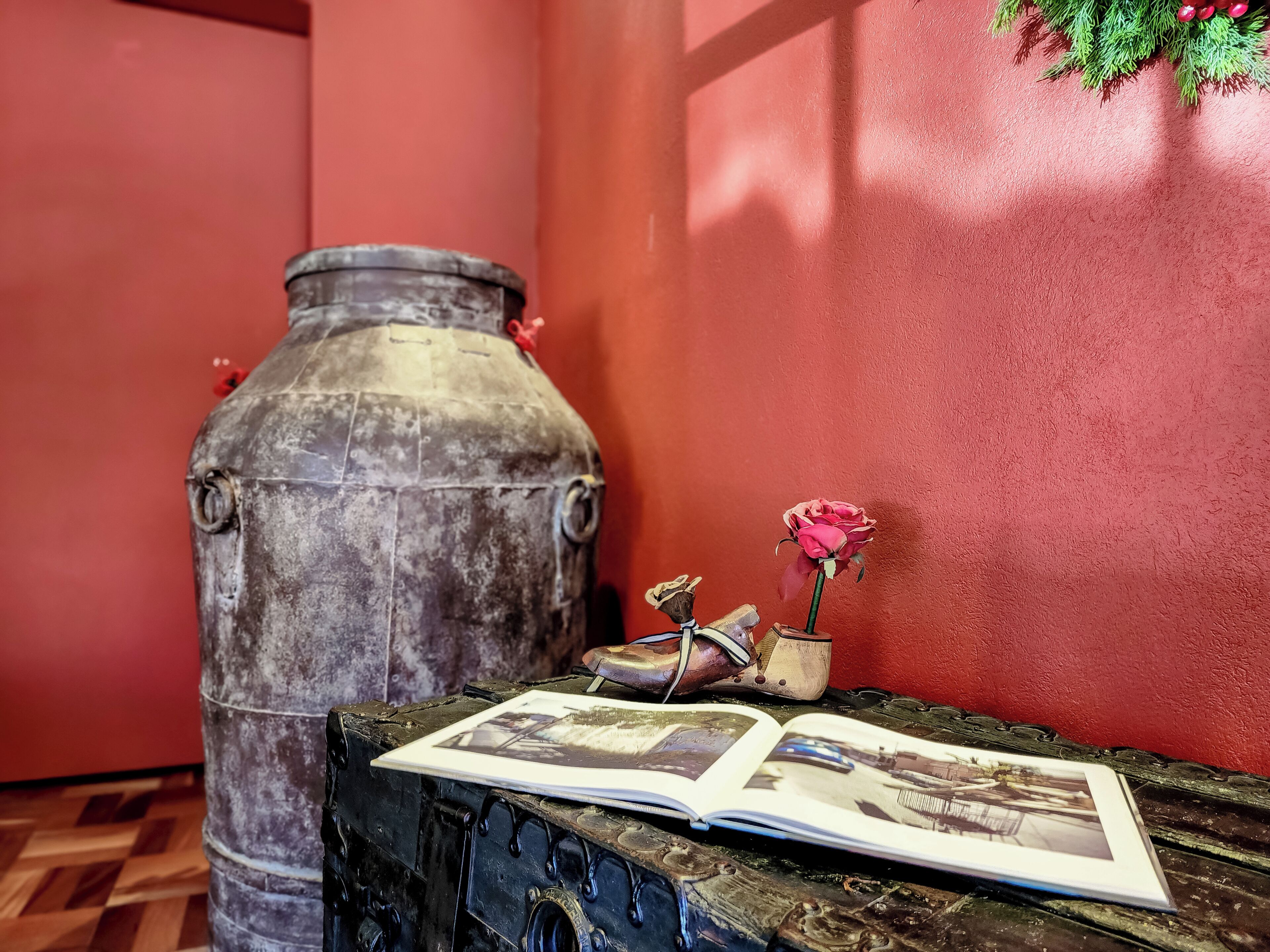 Un tavolo di legno rustico con un libro e un vaso con un solo fiore.