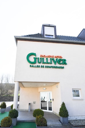 The exterior of the Gulliver Hotel with a sign indicating it is an exclusive hotel and a conference center. - Hotel Gulliver (Käerjeng)