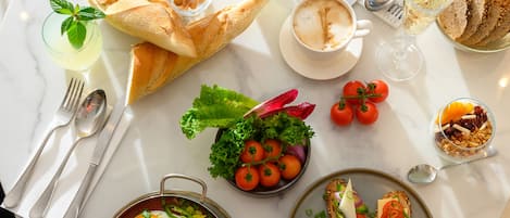 Una mesa redonda para comer con varios platos, incluyendo pan, ensalada y un tazón de sopa.