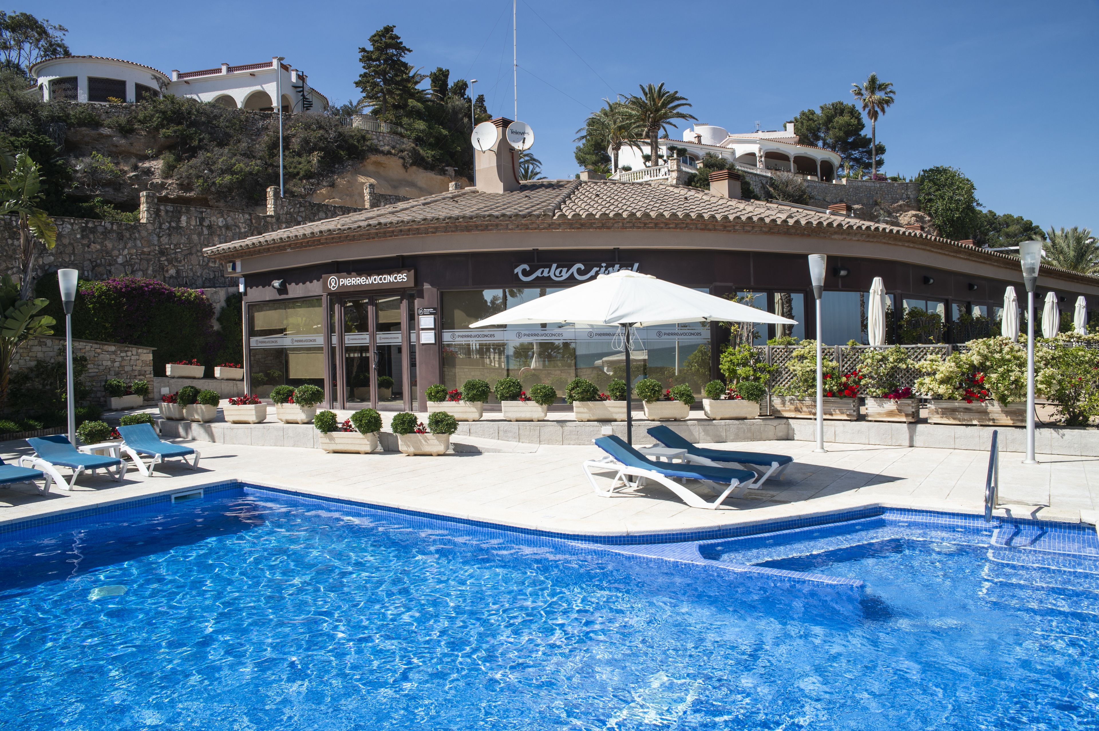Un área de piscina con sillones de descanso y un restaurante llamado 'Pierre'.