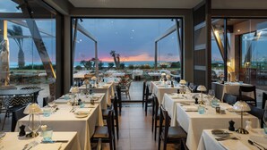 An outdoor dining area with tables set for dinner, overlooking a sunset view. - Hotel Riu Palace Tikida Agadir - All Inclusive (Agadir)
