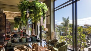 A spacious lobby with a large seating area, a coffee table, and hanging plants. - Hotel Riu Palace Tikida Agadir - All Inclusive (Agadir)