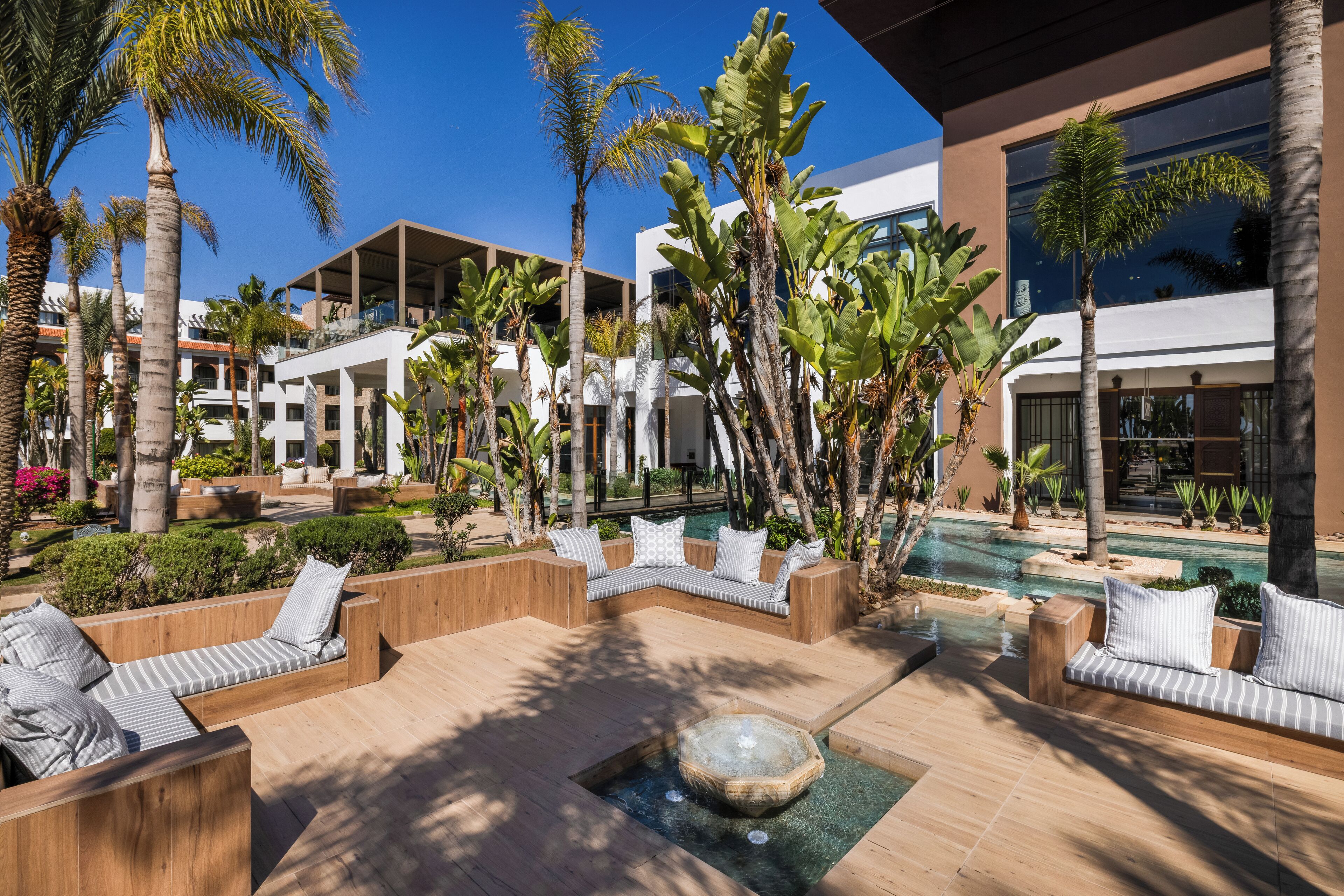 Ein Resort mit Außenbereichen, einem Pool und Palmen.