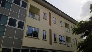 A multi-story building with a beige facade, large windows, and balconies. - Monarch Hotel (Accra)