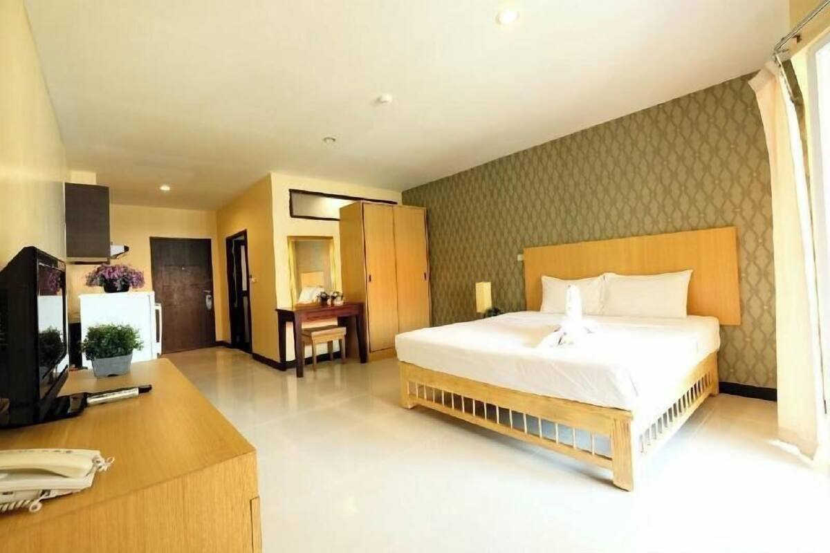 Ein Hotelzimmer mit Bett, Schreibtisch, Stuhl und Fernseher.