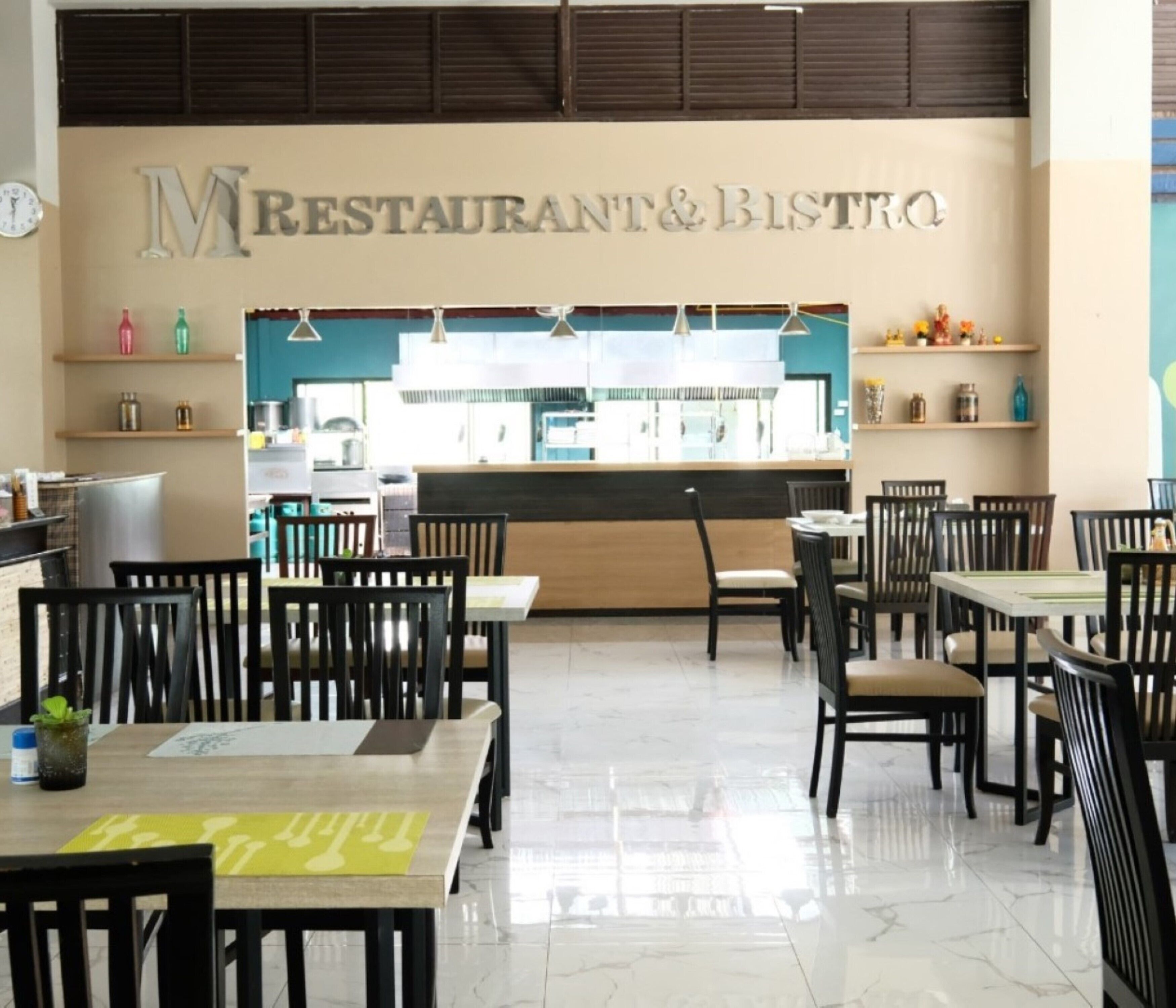 A restaurant interior with a counter, chairs, and tables.