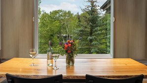 A dining table with a vase of flowers, two wine glasses, and a bottle of wine. - Terracehouse - CoralTree Residence Collection (Snowmass Village)