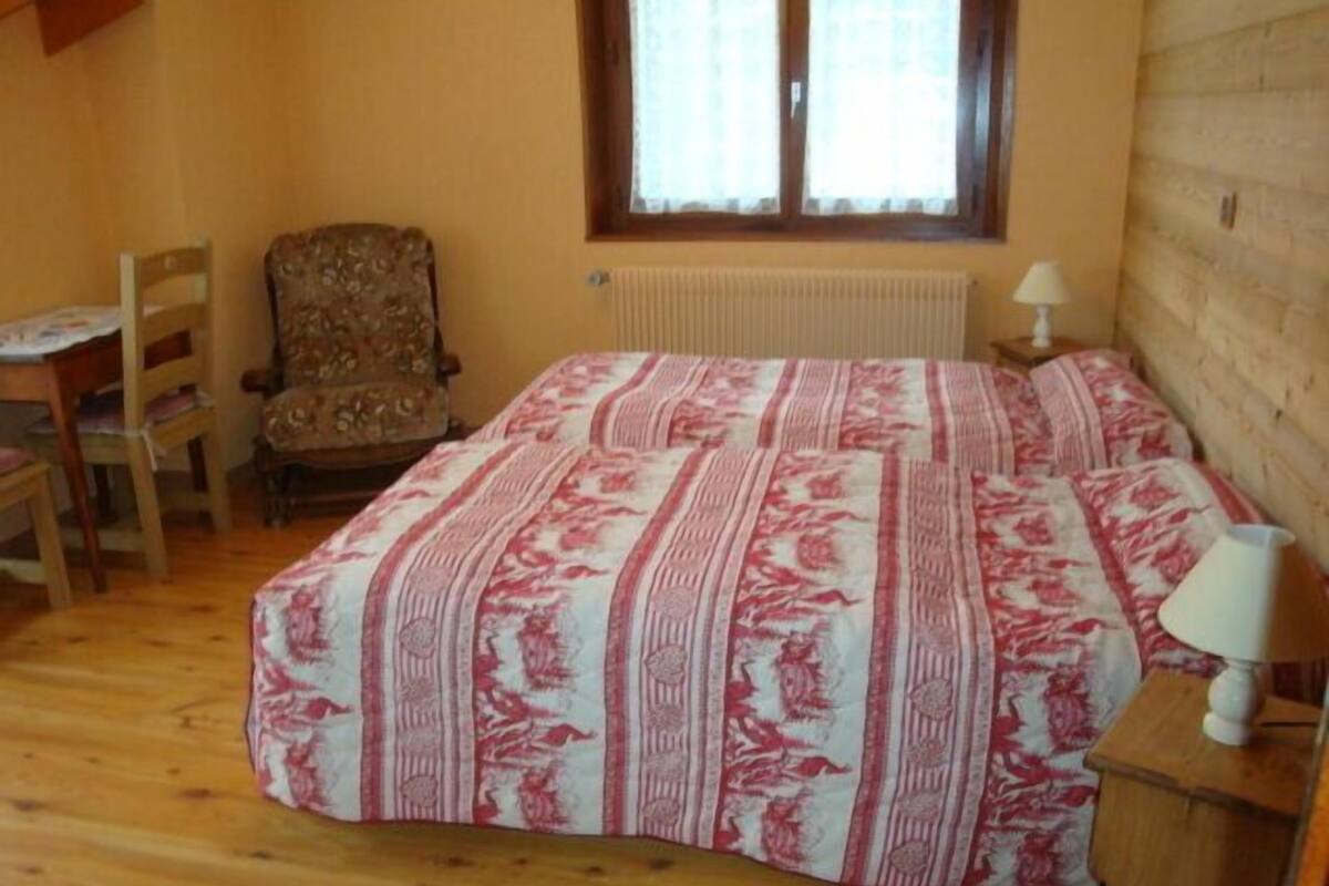 Makuuhuoneessa on sänky, tuoli, pöytä ja lamppu.