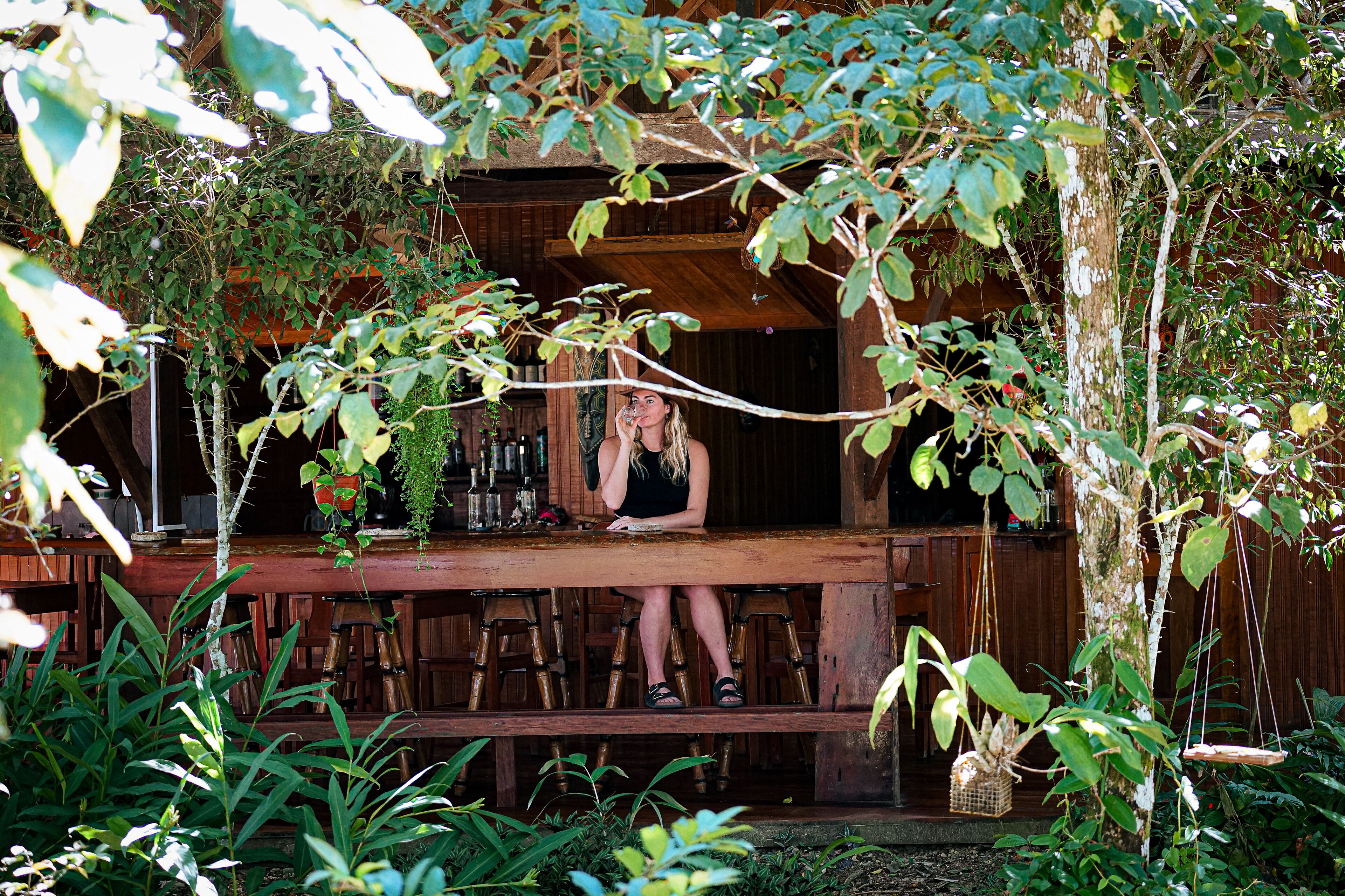 A wooden outdoor seating area with a person sitting at a table.