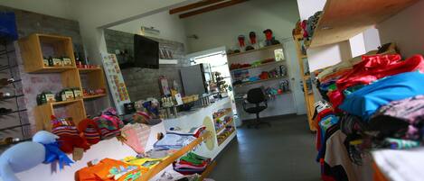 A clothing store with shelves of folded clothes and a variety of items on display.