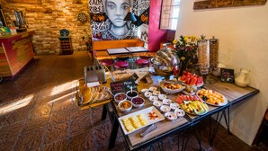 A buffet with various food items and a mural on the wall. - Masaya Bogotá (Bogotá)