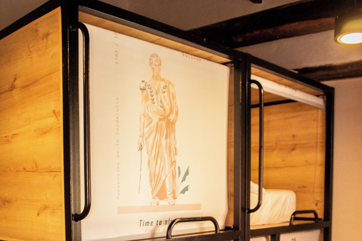 A bunk bed with a poster of a historical figure and a wooden floor.