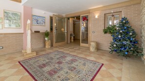 A spacious living area with a patterned rug, a Christmas tree, and a large window. - Residence Civetta (Val di Zoldo)