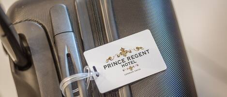 A close-up of a suitcase with a tag labeled "Prince Regent Hotel London Excel."