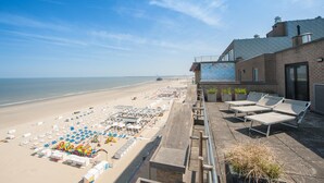 A beachside hotel with a terrace overlooking the beach, lounge chairs, and a view of the sea. - Beach Hotel Helios by CW Hotel Collection (Blankenberge)