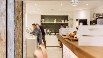 Een moderne keuken met een centraal kookeiland, witte kasten en een patroon backsplash.